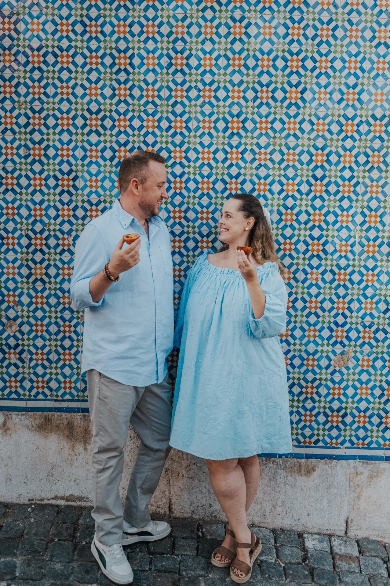 Pareja junto a un muro de azulejos azules en Lisboa