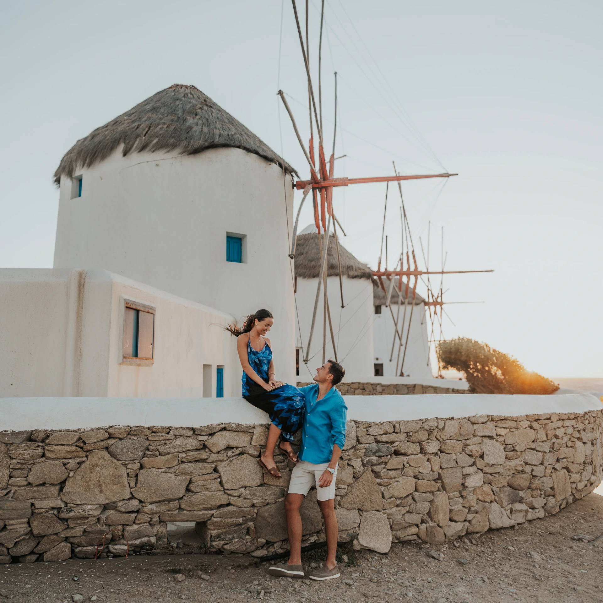Couple enjoying sunset beside the Mykonos windmills