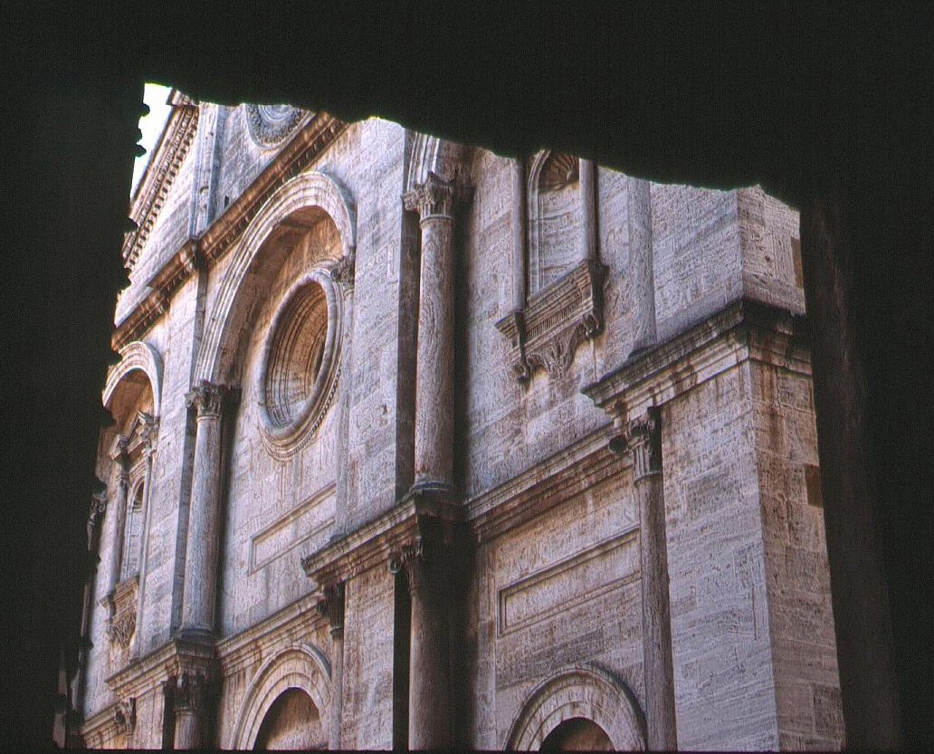 Detail of Pienza Cathedral’s façade, seen through a window