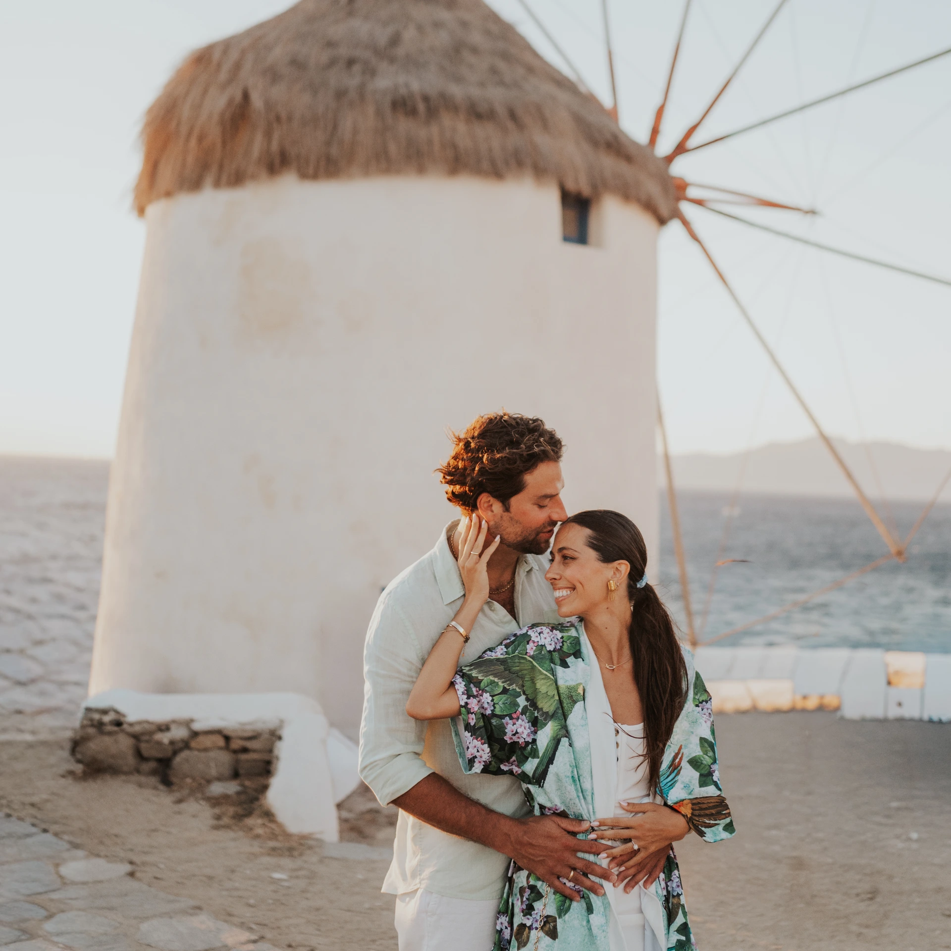 Couple portrait beside a white windmill in Mykonos