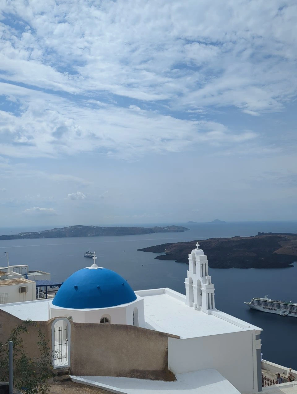 Cúpula azul y campanario blanco de las Three Bells en Firostefani
