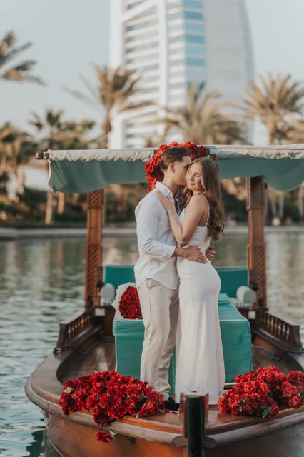 A couple embraces on a decorated abra in Souk Madinat during a romantic proposal photoshoot.
