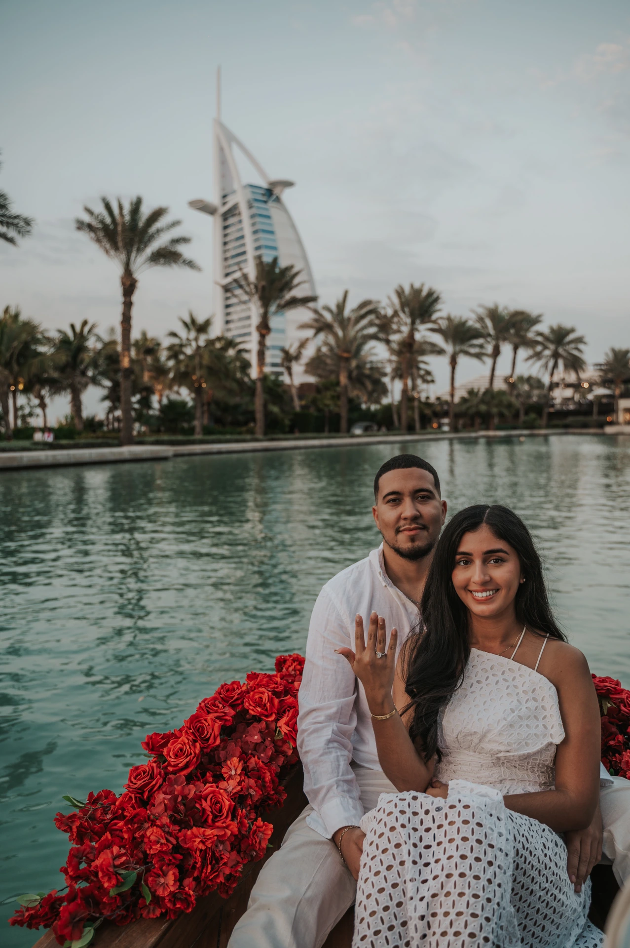 A newly engaged couple poses on an abra as the bride-to-be shows her ring at Souk Madinat.