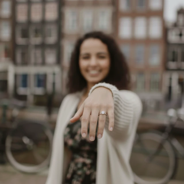Proposal photographer Amsterdam A woman showing her diamond ring posing for a proposal photographer in Amsterdam.