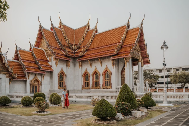 Woman in a red dress in the grounds of Wat Benchamabophit in Bangkok