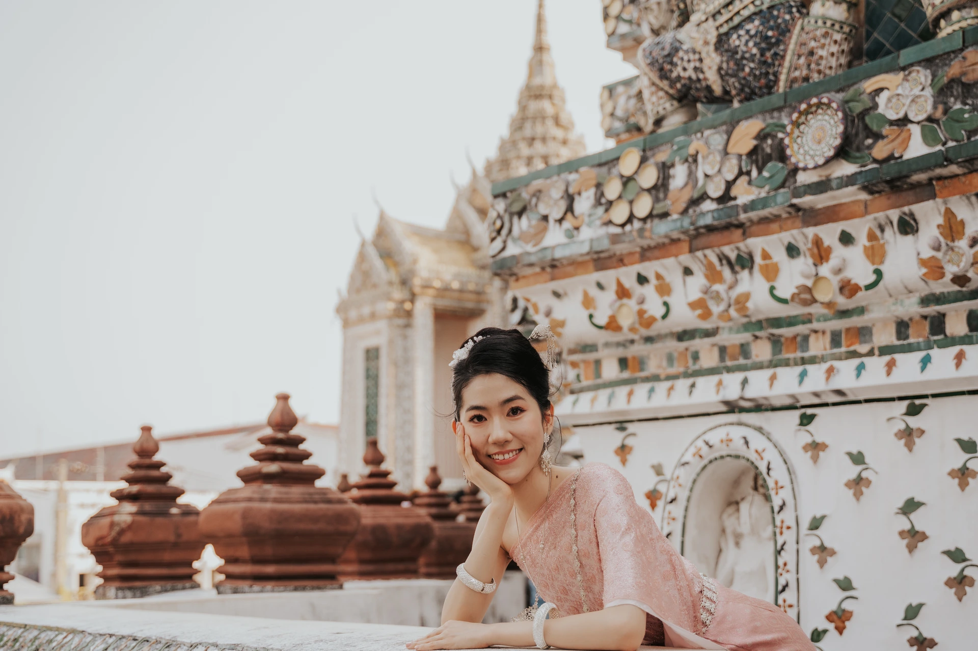 Solo traveller in pink Thai dress at Wat Arun in Bangkok