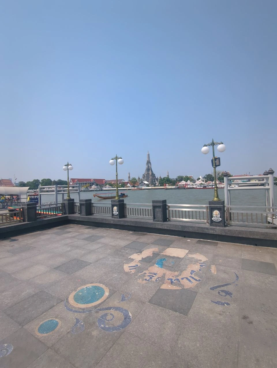 Bangkok Proposal Locations - Tha Tian Viewpoint An open Tha Tian riverside platform faces Wat Arun, with a boat crossing the Chao Phraya through this Bangkok proposal setting.