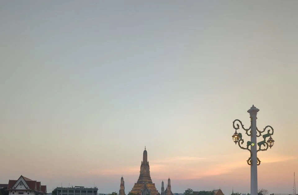 Wat Arun rises beneath a warm evening sky, creating an iconic backdrop for a Bangkok family photoshoot.