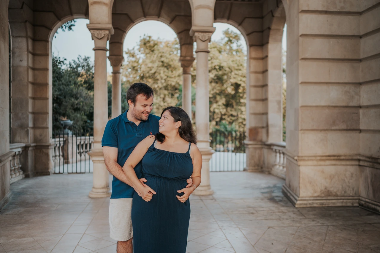 A portrait together beneath the arches | Barcelona family photoshoot The parents standing close together beneath the stone arches during their family photoshoot in Barcelona.