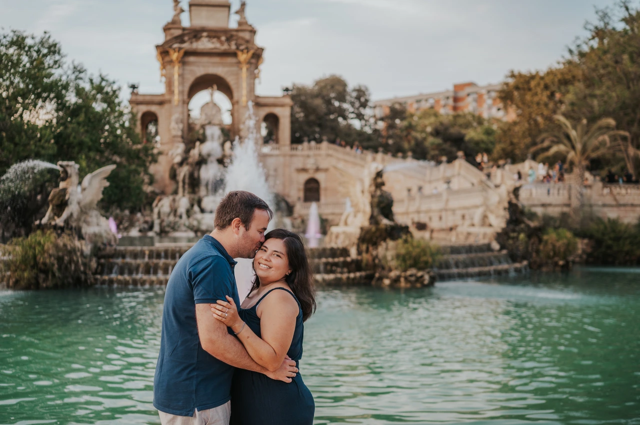 A forehead kiss by the water | Barcelona family photoshoot The father leaning towards the mother for a forehead kiss beside the fountain during their family photoshoot in Barcelona.