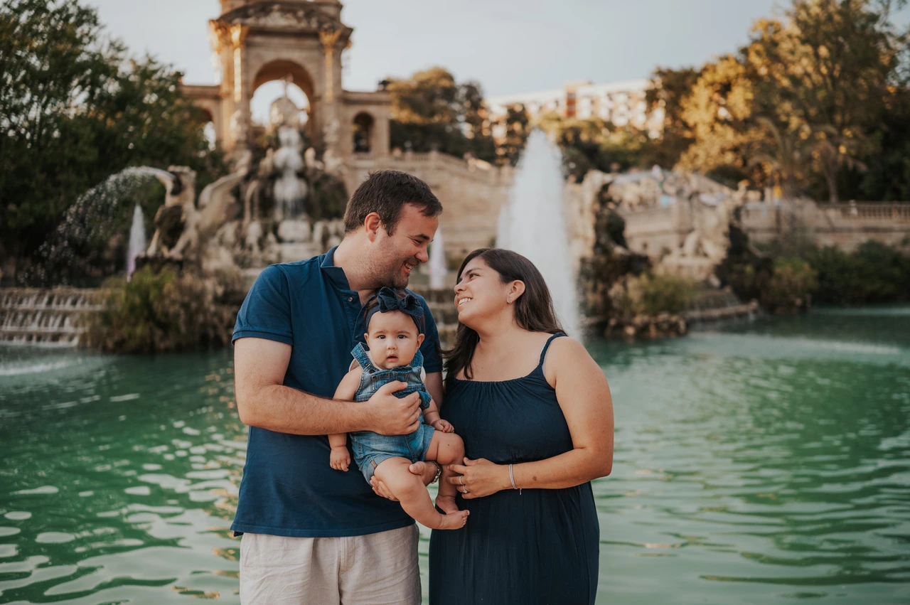 Cuddles by the fountain | Barcelona family photoshoot The parents turning towards each other and their child beside the fountain during their family photoshoot in Barcelona.