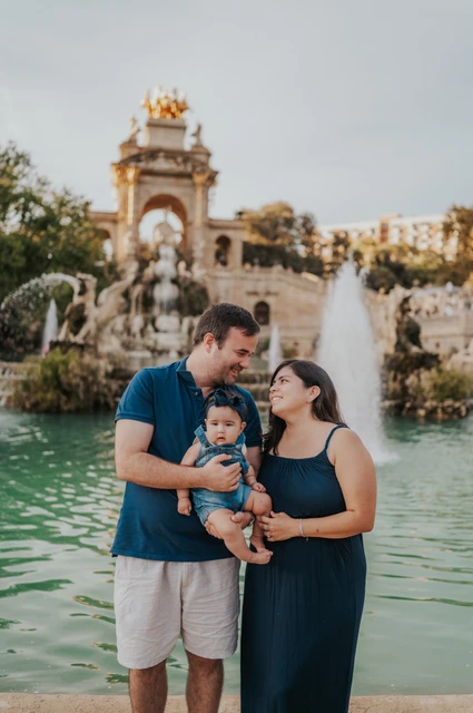 Cuddles by the fountain | Barcelona family photoshoot The parents turning towards each other and their child beside the fountain during their family photoshoot in Barcelona.