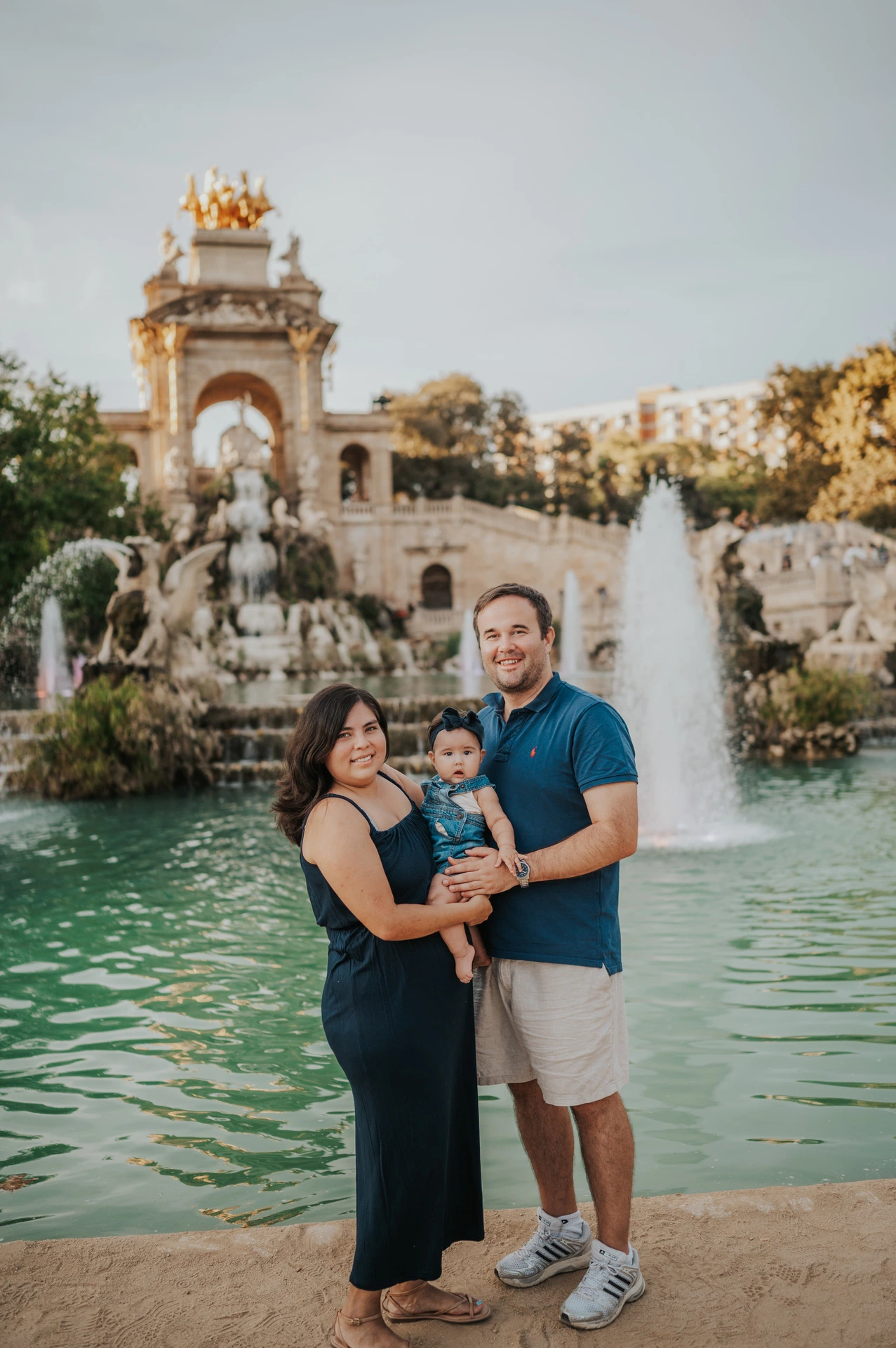 The family standing close together with the fountain behind them during their family photoshoot in Barcelona.