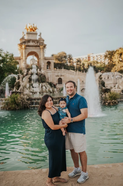 Together in front of the fountain | Barcelona family photoshoot The family standing close together with the fountain behind them during their family photoshoot in Barcelona.