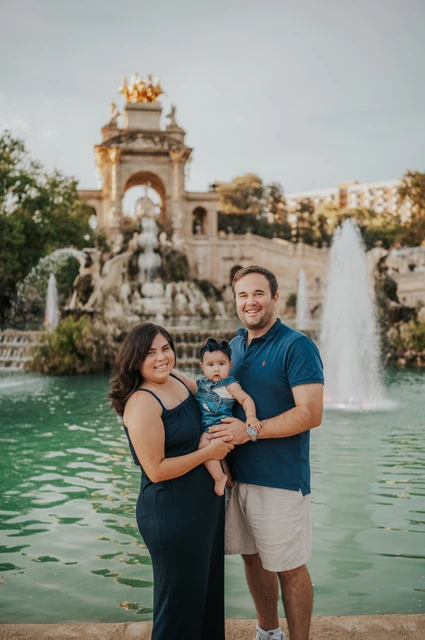 Together in front of the fountain | Barcelona family photoshoot The family standing close together with the fountain behind them during their family photoshoot in Barcelona.
