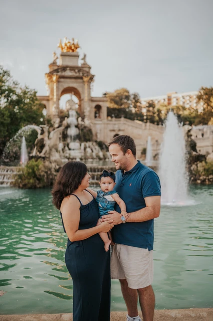 Together in front of the fountain | Barcelona family photoshoot The family standing close together with the fountain behind them during their family photoshoot in Barcelona.