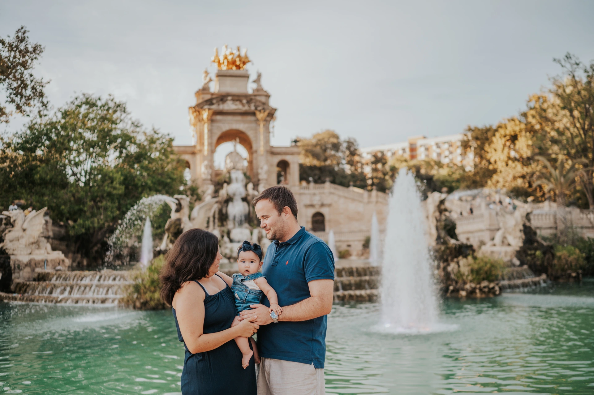 The family standing close together with the fountain behind them during their family photoshoot in Barcelona.