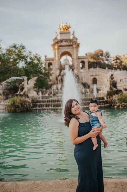 Mother and child beside the fountain | Barcelona family photoshoot The mother holding her child in front of the green fountain pool during their family photoshoot in Barcelona.