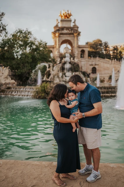 Kisses for their little one | Barcelona family photoshoot Both parents leaning close to kiss their child beside the water during their family photoshoot in Barcelona.