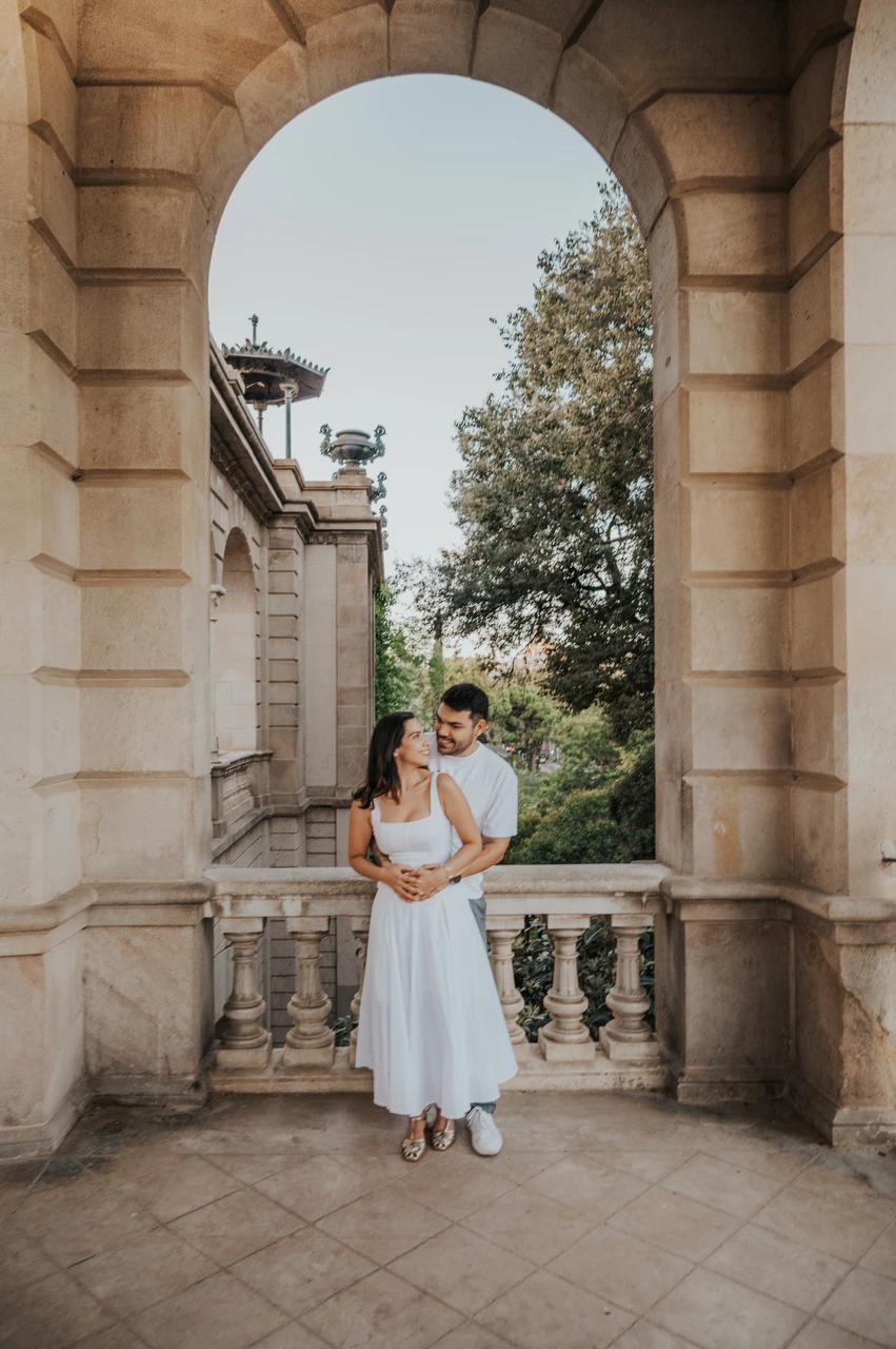 A full-length portrait framed by an arch | Barcelona engagement photoshoot A full-length portrait of the couple holding each other in a tall stone archway during their engagement photoshoot in Barcelona.