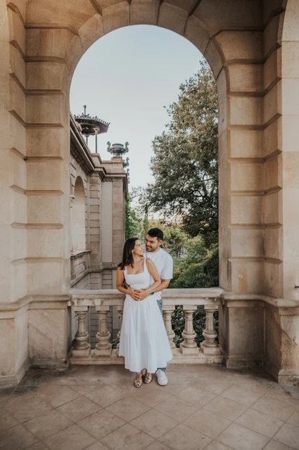 A full-length portrait framed by an arch | Barcelona engagement photoshoot A full-length portrait of the couple holding each other in a tall stone archway during their engagement photoshoot in Barcelona.