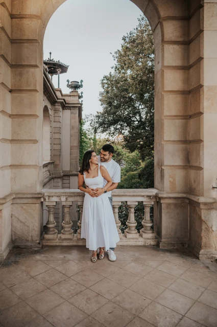 A full-length portrait framed by an arch | Barcelona engagement photoshoot A full-length portrait of the couple holding each other in a tall stone archway during their engagement photoshoot in Barcelona.
