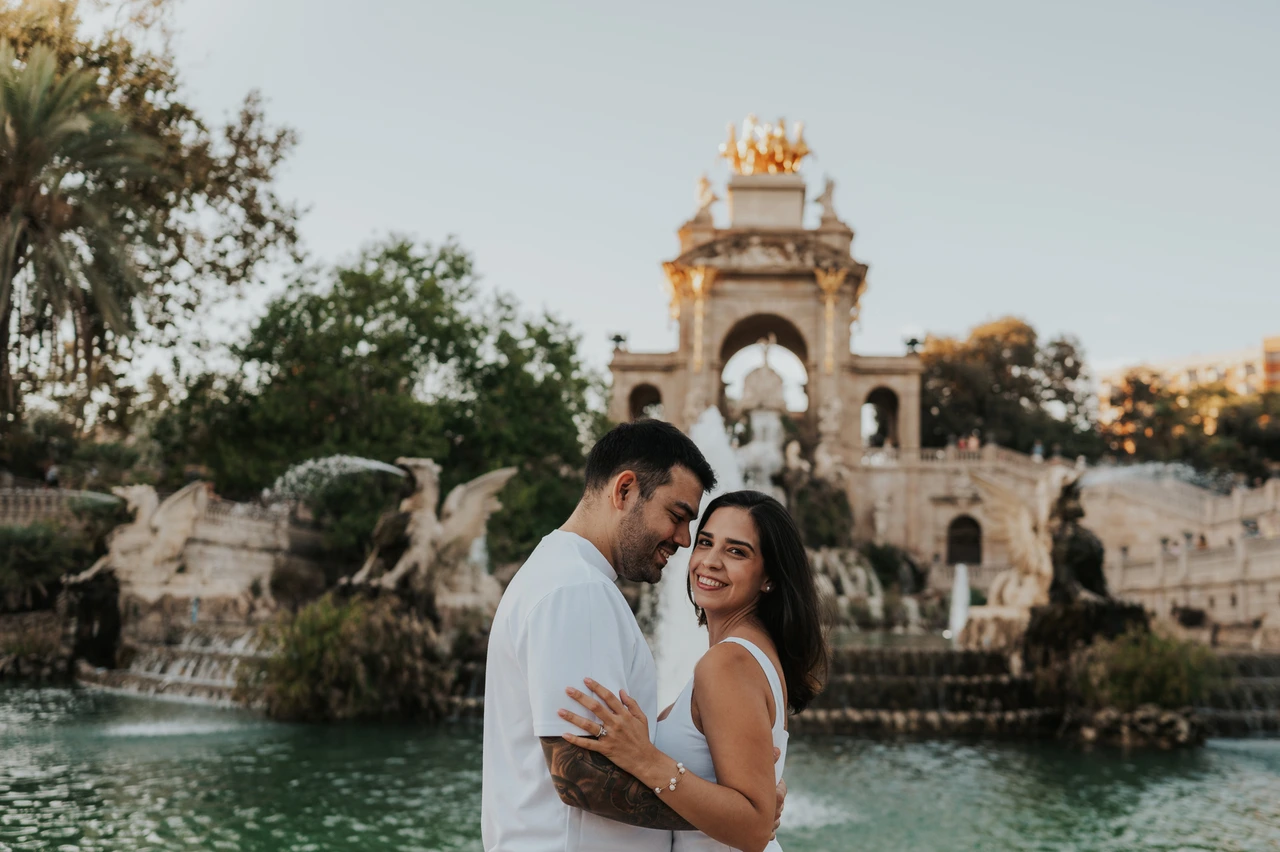 A close portrait beside the fountain | Barcelona engagement photoshoot The couple holding each other in front of the fountain, with the woman turning towards the camera during their engagement photoshoot in Barcelona.