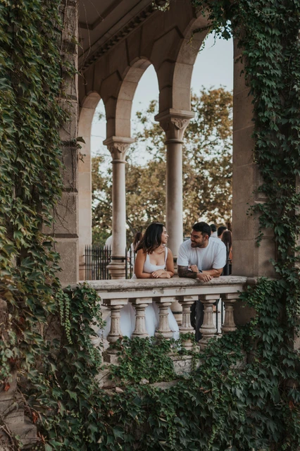 Portraits framed by ivy-covered arches | Barcelona engagement photoshoot The couple leaning towards each other behind a stone balustrade framed by ivy-covered arches during their engagement photoshoot in Barcelona.
