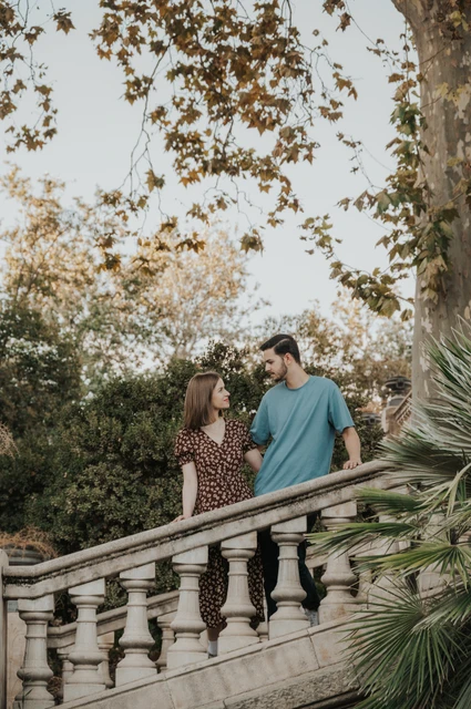 A closer portrait of the couple leaning towards each other behind the staircase balustrade during their couple photoshoot in Barcelona.