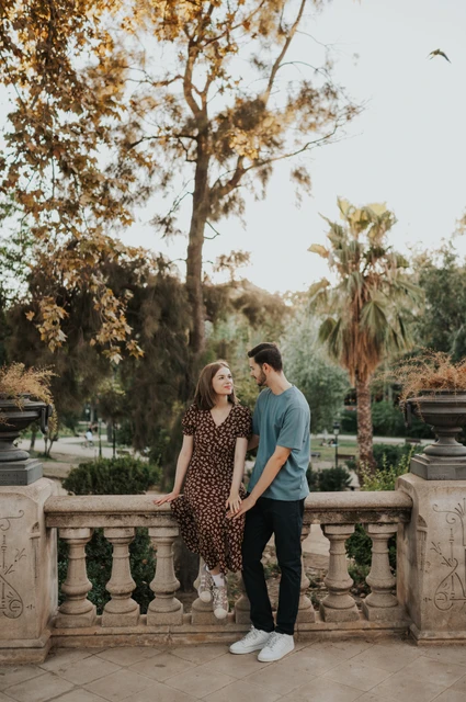 A portrait between the stone urns | Barcelona couple photoshoot The couple facing each other beside the park balustrade and carved stone urns during their couple photoshoot in Barcelona.