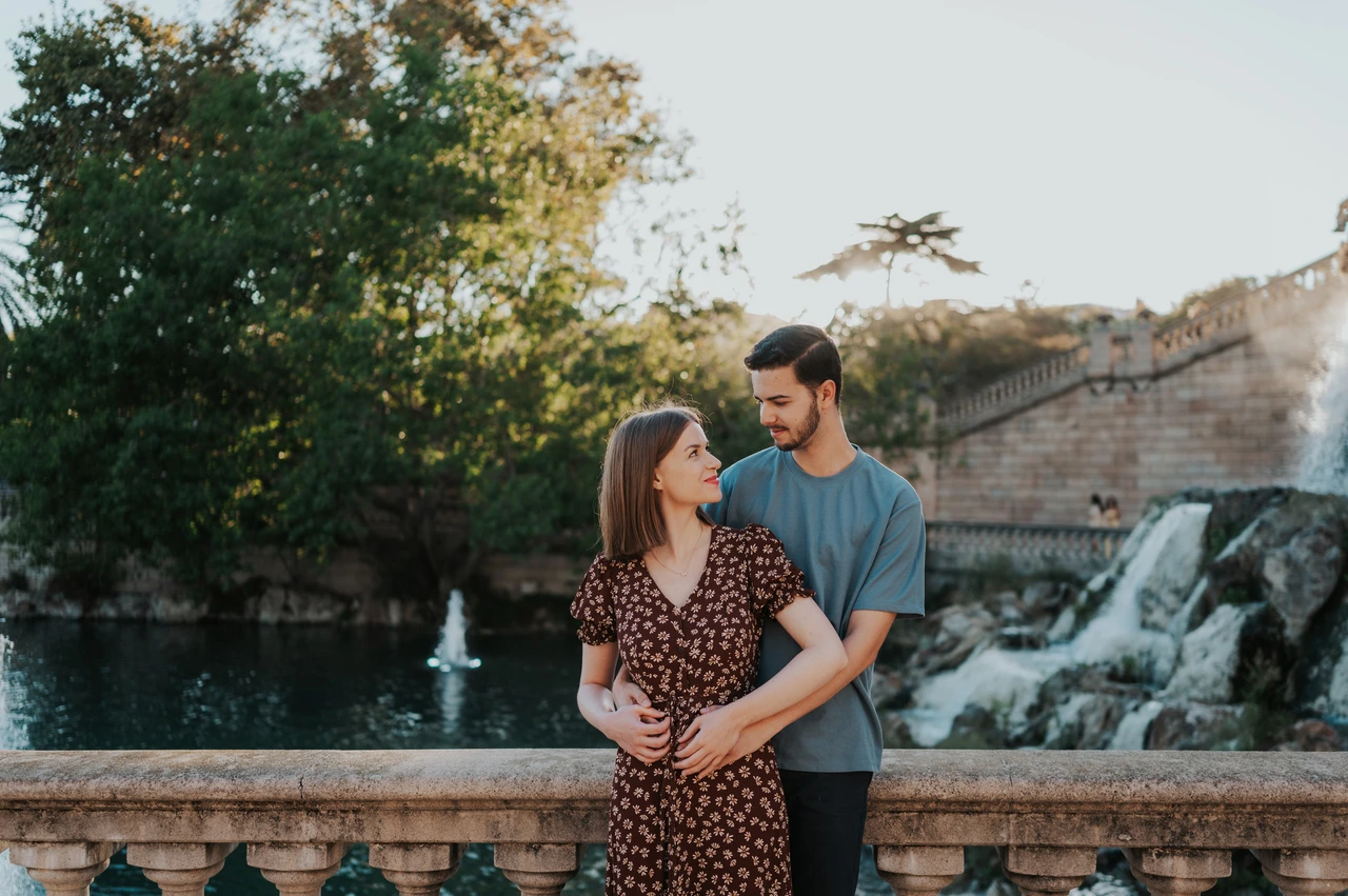 An embrace beside the waterfall | Barcelona couple photoshoot The couple holding each other beside the stone balustrade, with the waterfall behind them during their couple photoshoot in Barcelona.