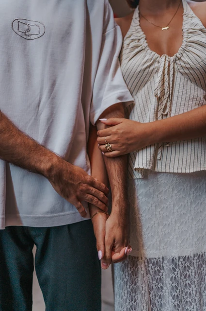 A little detail of their joined hands | Barcelona couple photoshoot A close detail of the couple holding hands, with the woman’s other hand resting on her partner’s forearm during their couple photoshoot in Barcelona.