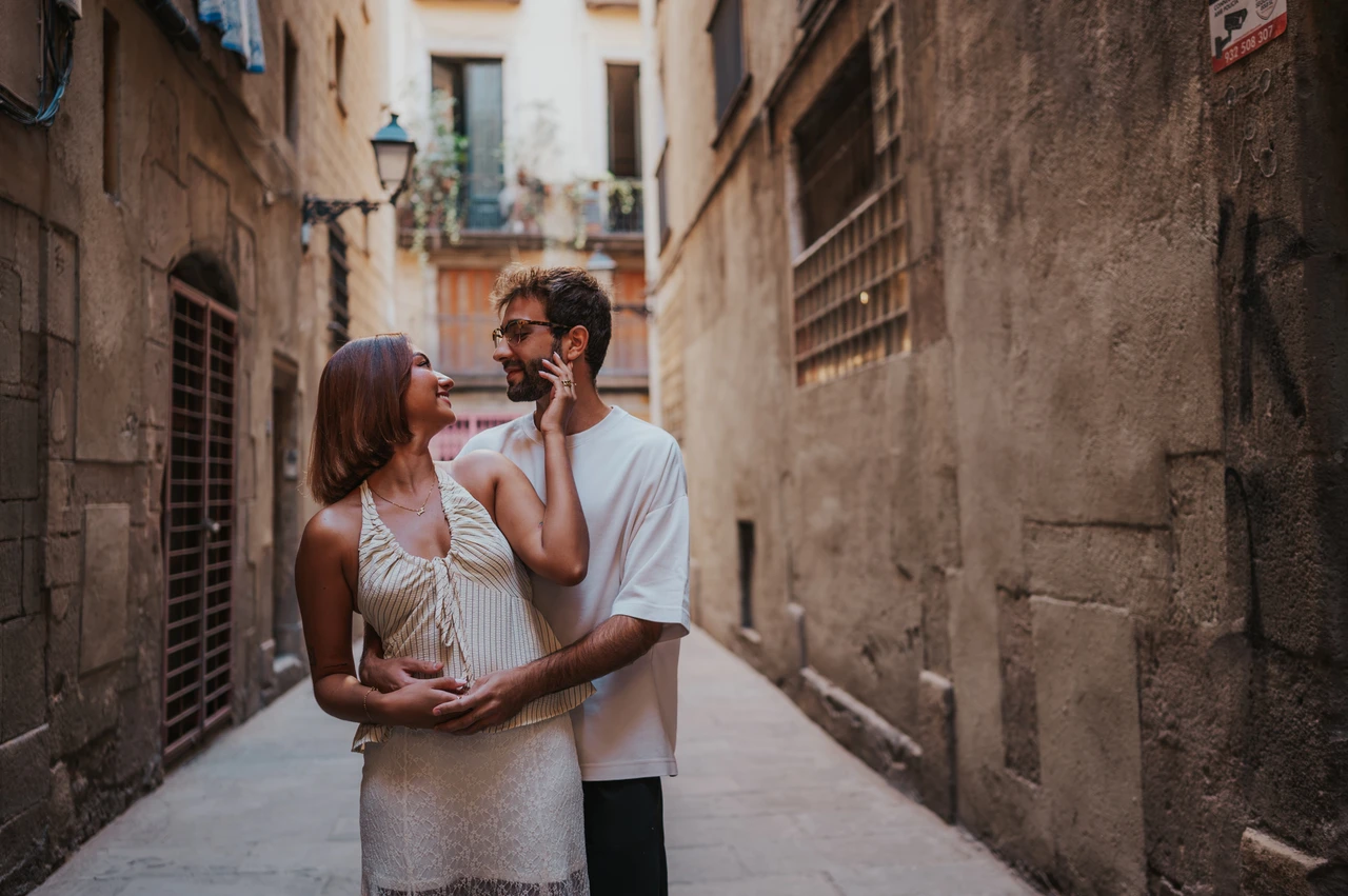 Smiling together among the old streets | Barcelona couple photoshoot The couple smiling at each other while embracing in a narrow stone lane during their couple photoshoot in Barcelona.