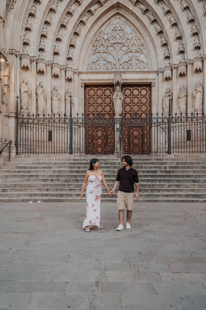Hand in hand outside Barcelona Cathedral | Barcelona couple photoshoot The couple holding hands in front of Barcelona Cathedral’s carved entrance and broad stone steps during their couple photoshoot in Barcelona.