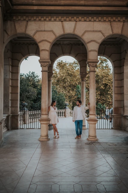 Portraits among the pavilion columns | Barcelona engagement photoshoot The couple framed by the stone columns and arches of an open park pavilion during their engagement photoshoot in Barcelona.