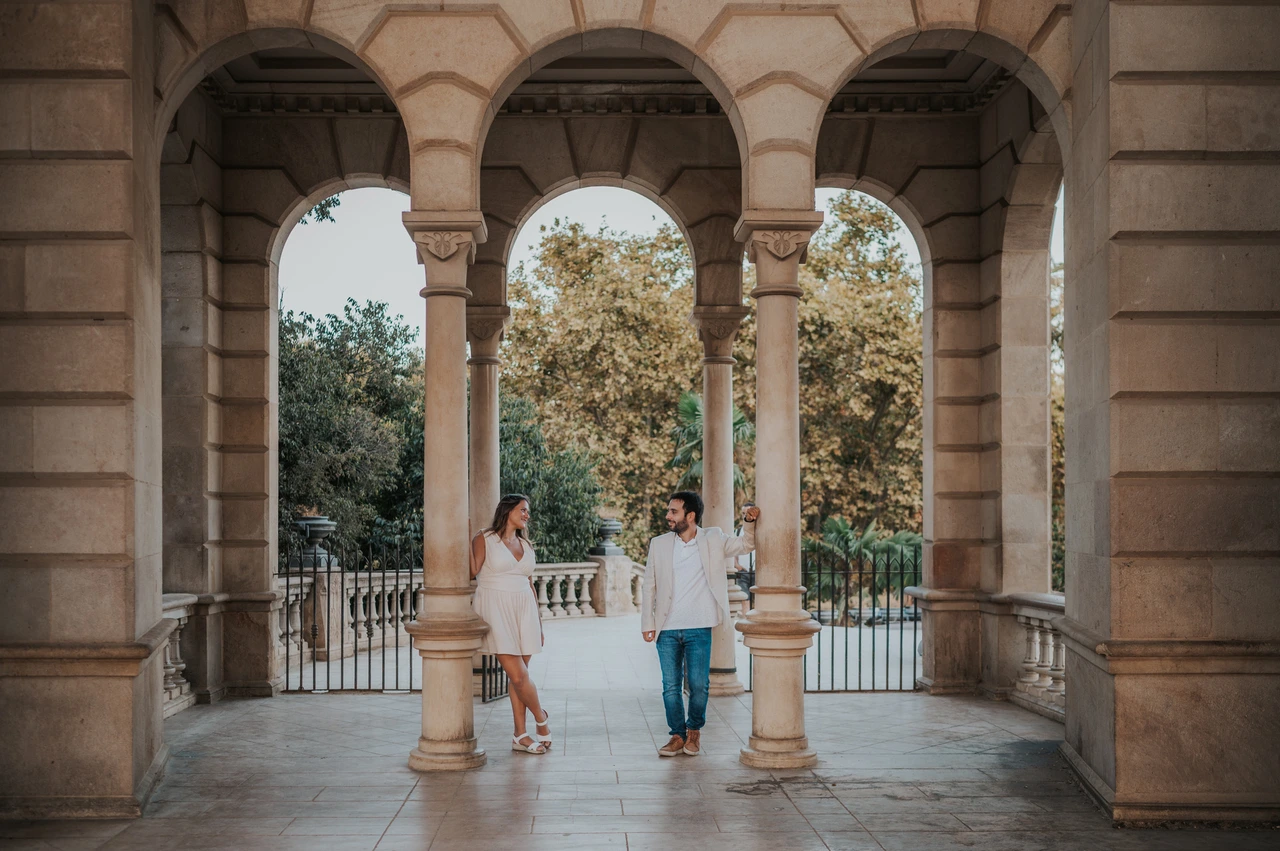 Portraits among the pavilion columns | Barcelona engagement photoshoot The couple framed by the stone columns and arches of an open park pavilion during their engagement photoshoot in Barcelona.
