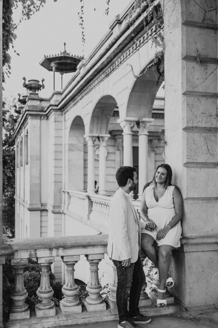 A close portrait beside the ivy-covered arch in black and white | Barcelona engagement photoshoot Black-and-white photograph: the couple close together beside an ivy-covered stone arch and balustrade during their engagement photoshoot in Barcelona.