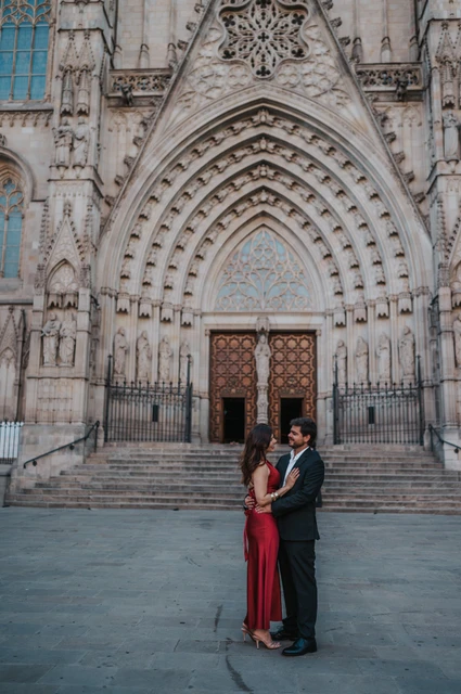 The couple standing close together in front of Barcelona Cathedral’s carved Gothic entrance during their engagement photoshoot in Barcelona.
