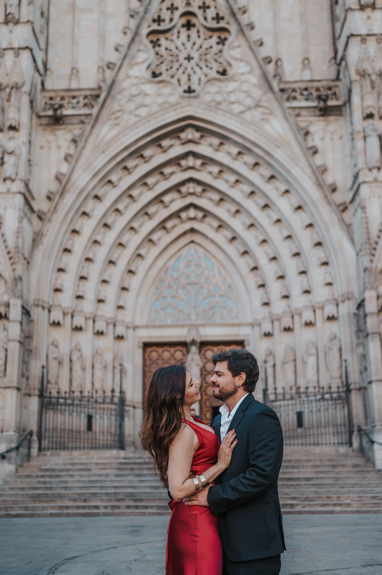 The couple standing close together in front of Barcelona Cathedral’s carved Gothic entrance during their engagement photoshoot in Barcelona.