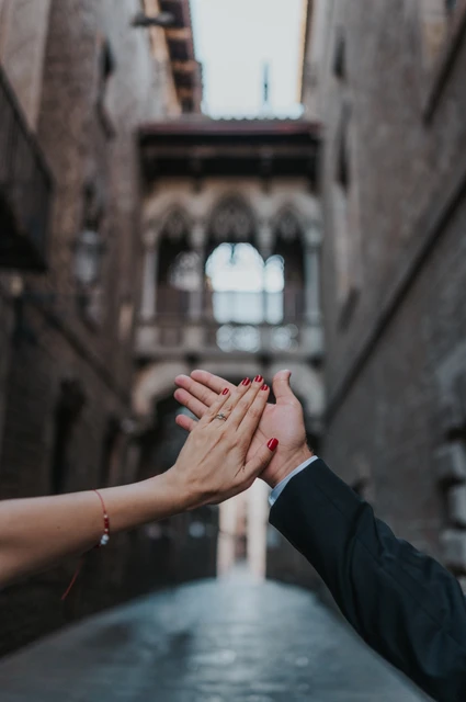 An engagement ring with Pont del Bisbe in the background | Barcelona engagement photoshoot A close-up of the couple’s raised hands and engagement ring, with Pont del Bisbe softly blurred behind them during their engagement photoshoot in Barcelona.