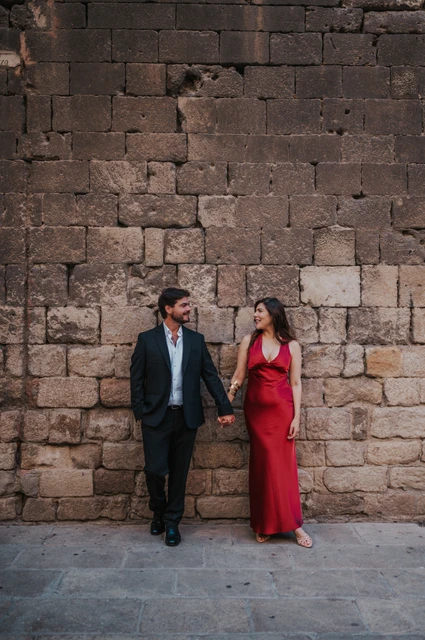 Portraits against the old town’s stone walls | Barcelona engagement photoshoot The couple standing together against a textured historic stone wall in the Gothic Quarter during their engagement photoshoot in Barcelona.