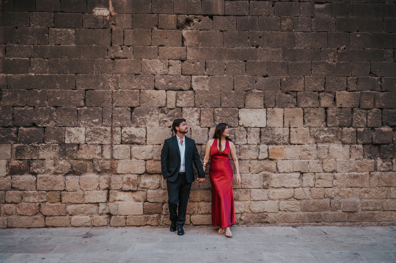 Portraits against the old town’s stone walls | Barcelona engagement photoshoot The couple standing together against a textured historic stone wall in the Gothic Quarter during their engagement photoshoot in Barcelona.