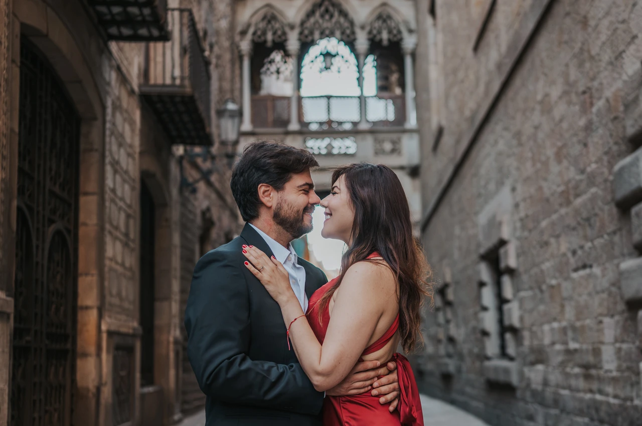 A close portrait beneath Pont del Bisbe | Barcelona engagement photoshoot A close portrait of the couple embracing beneath Pont del Bisbe in the Gothic Quarter during their engagement photoshoot in Barcelona.