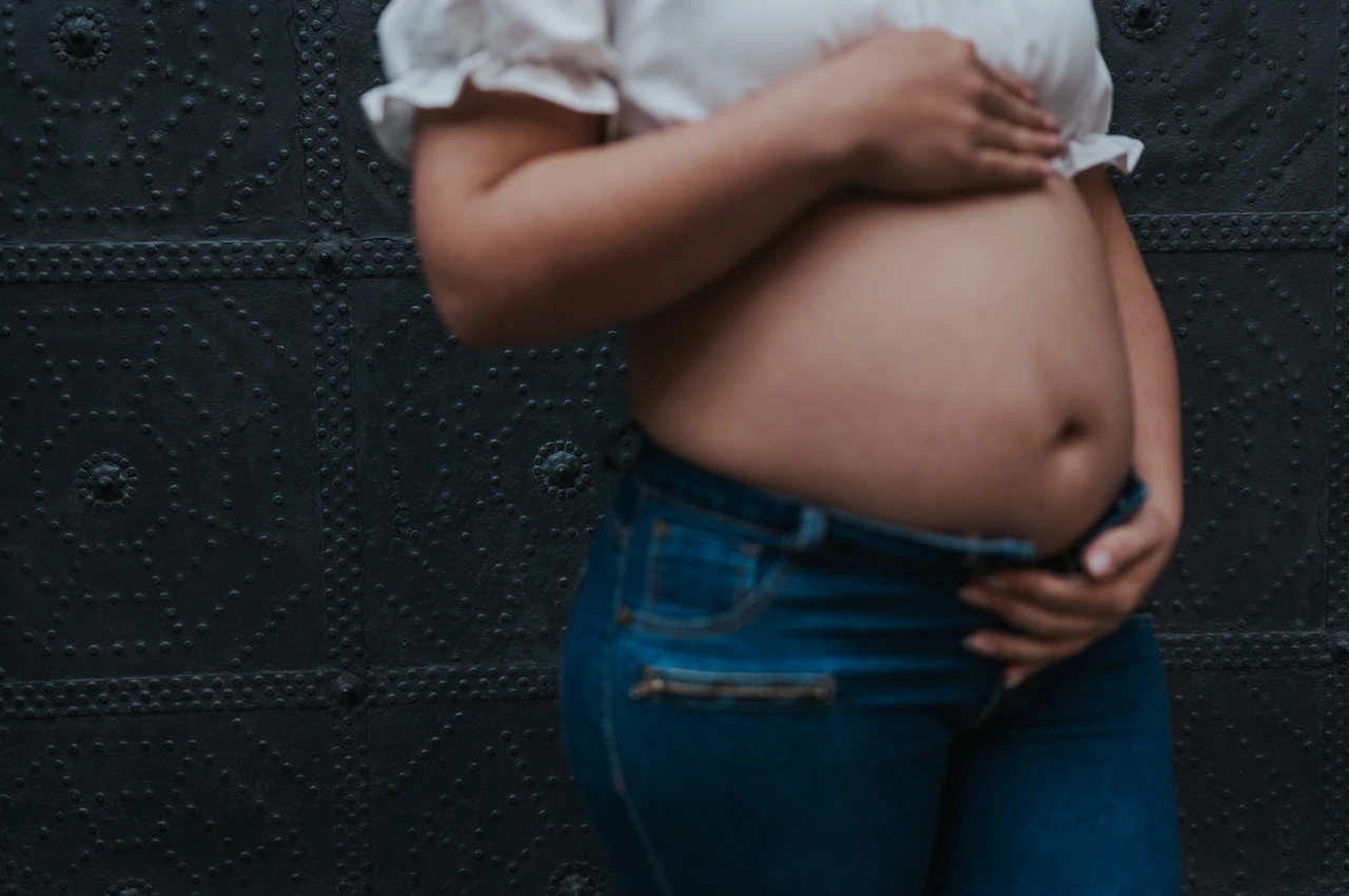 Hands resting on her bump | Barcelona maternity photoshoot A close view of the mother-to-be’s hands resting on her bump against a dark door during their maternity photoshoot in Barcelona.