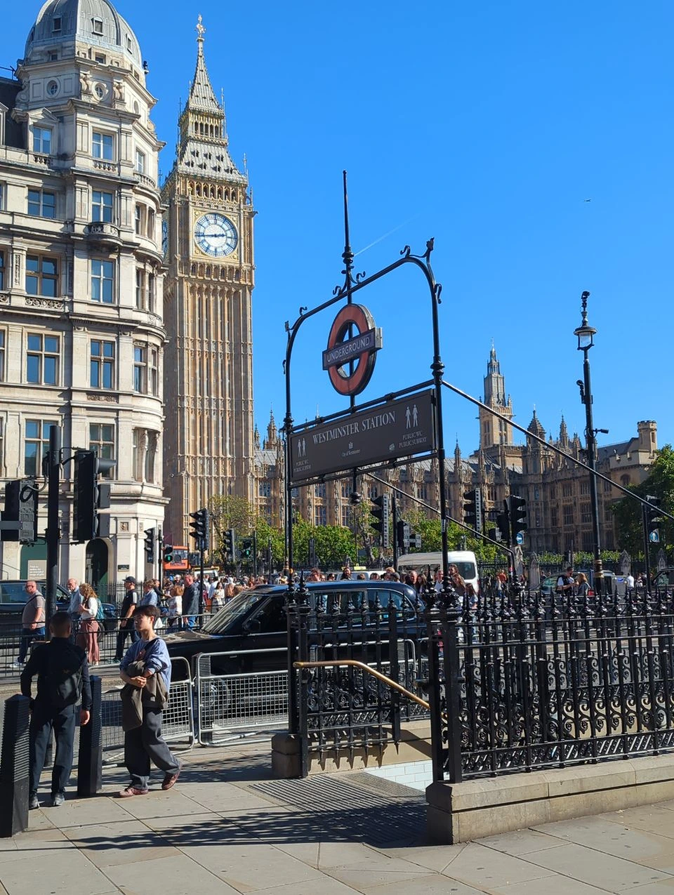 Westminster Station’s Underground roundel and iron stair railings with Elizabeth Tower rising behind