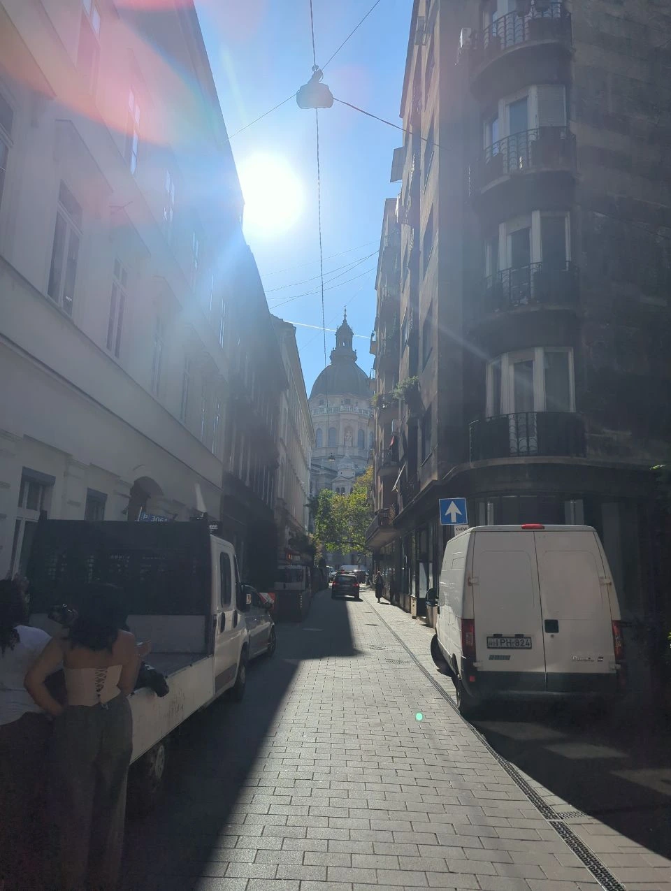 St Stephen's Basilica side street Backlit narrow street with St Stephen's Basilica dome and parked vans