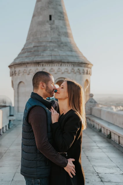 A close portrait beside the pointed tower at a Budapest couple photoshoot A close portrait of the couple leaning towards one another beneath a pointed tower at Fisherman’s Bastion during their couple photoshoot in Budapest.