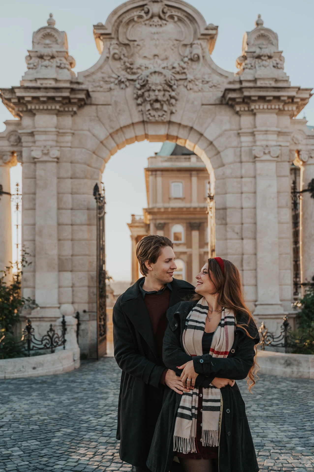 Close portrait of a couple embracing in front of the Buda Castle gate during their photoshoot in Budapest