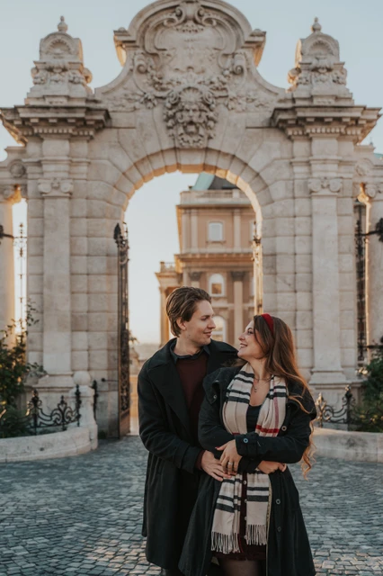 Close couple photoshoot in Budapest at the castle gate Close portrait of a couple embracing in front of the Buda Castle gate during their photoshoot in Budapest