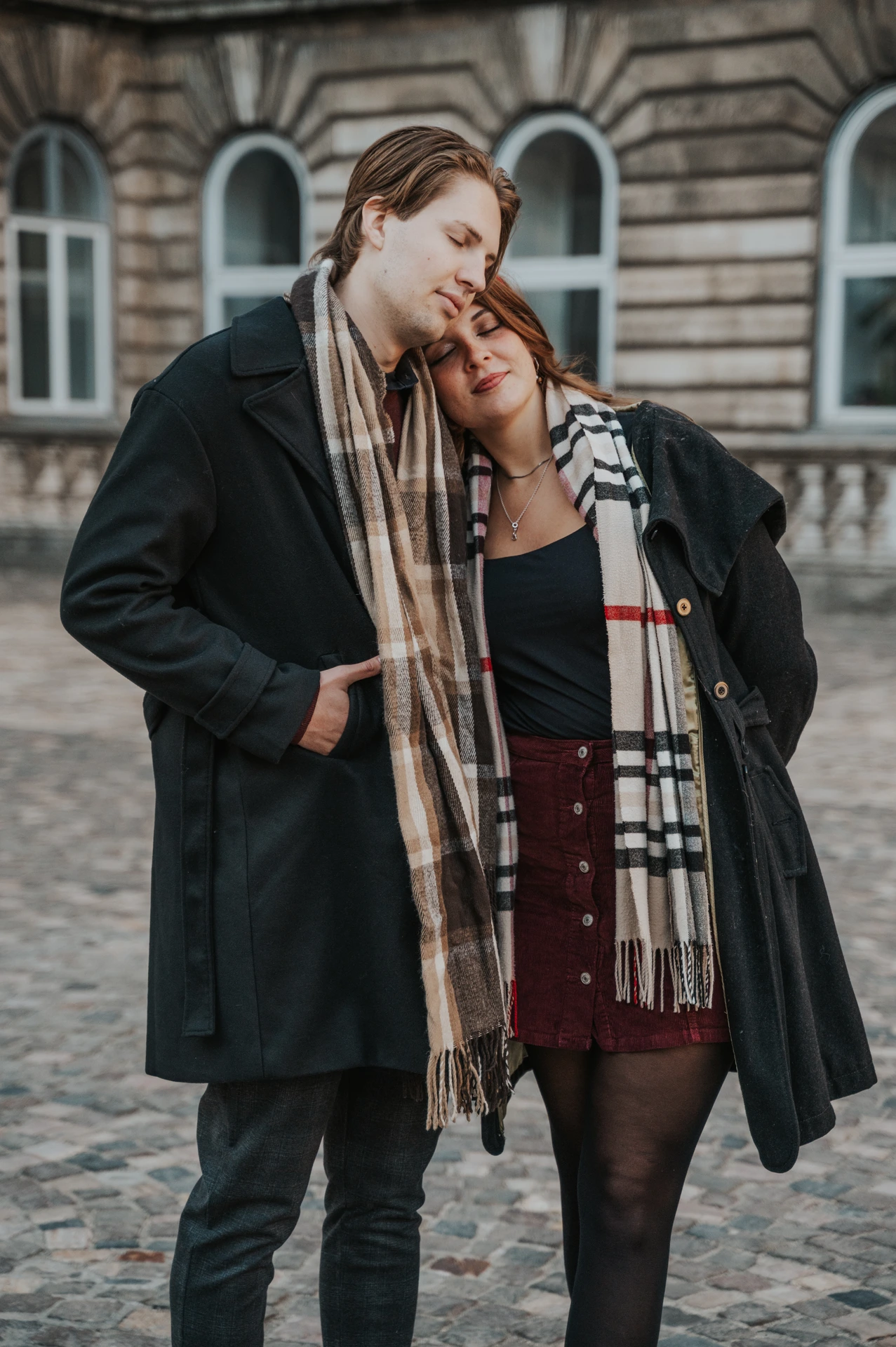 Close portrait of a forehead kiss beside the Buda Castle facade during the couple's morning photoshoot in Budapest